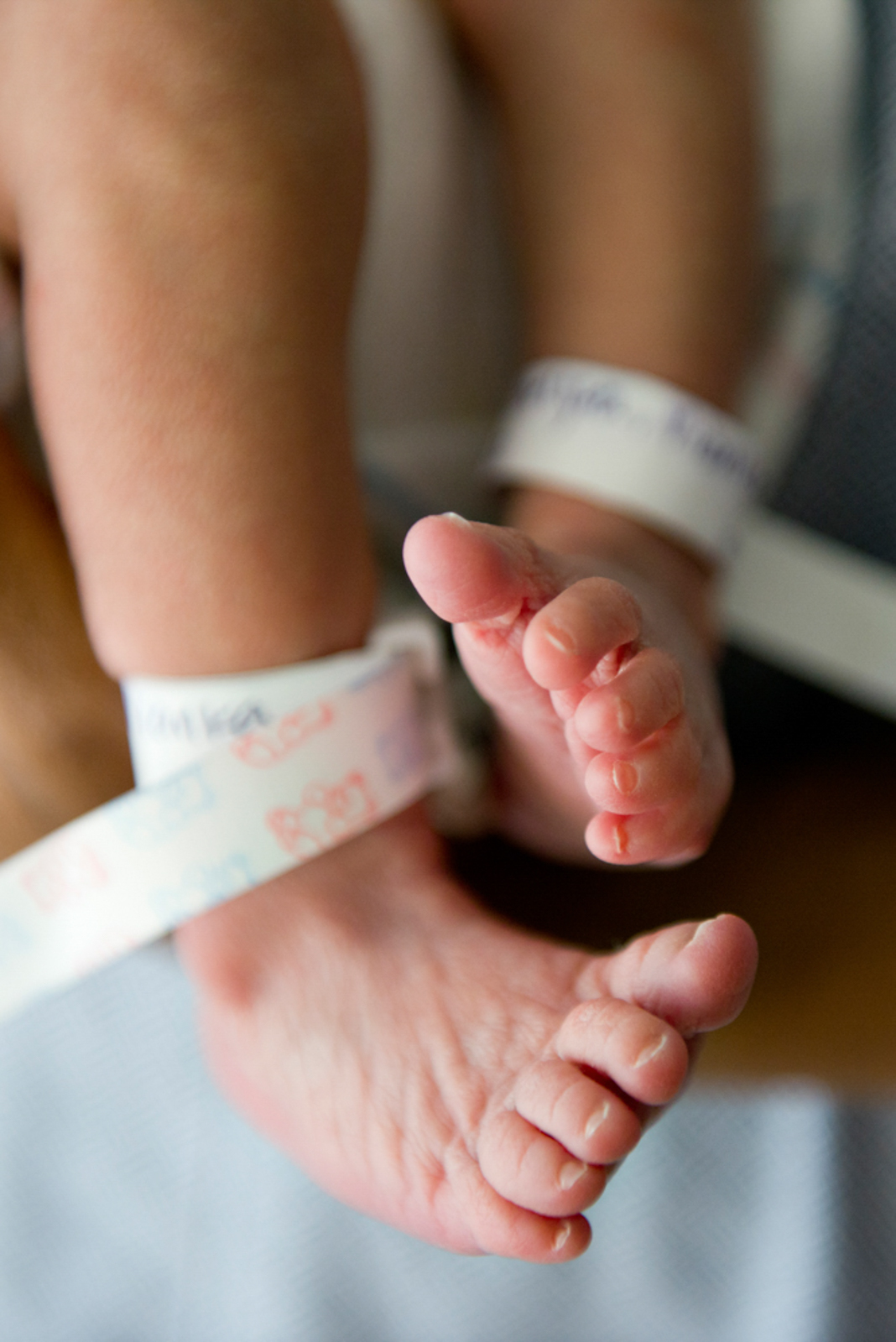 Detail shot of newborn's feet, with tags around ankles