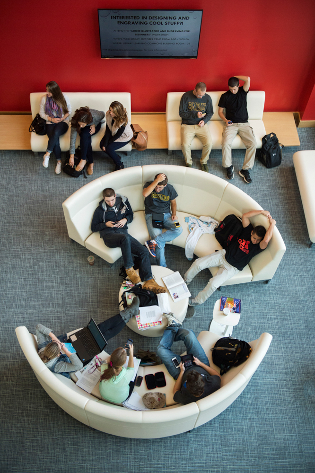 Overhead shot of students sitting on round couches, socializing