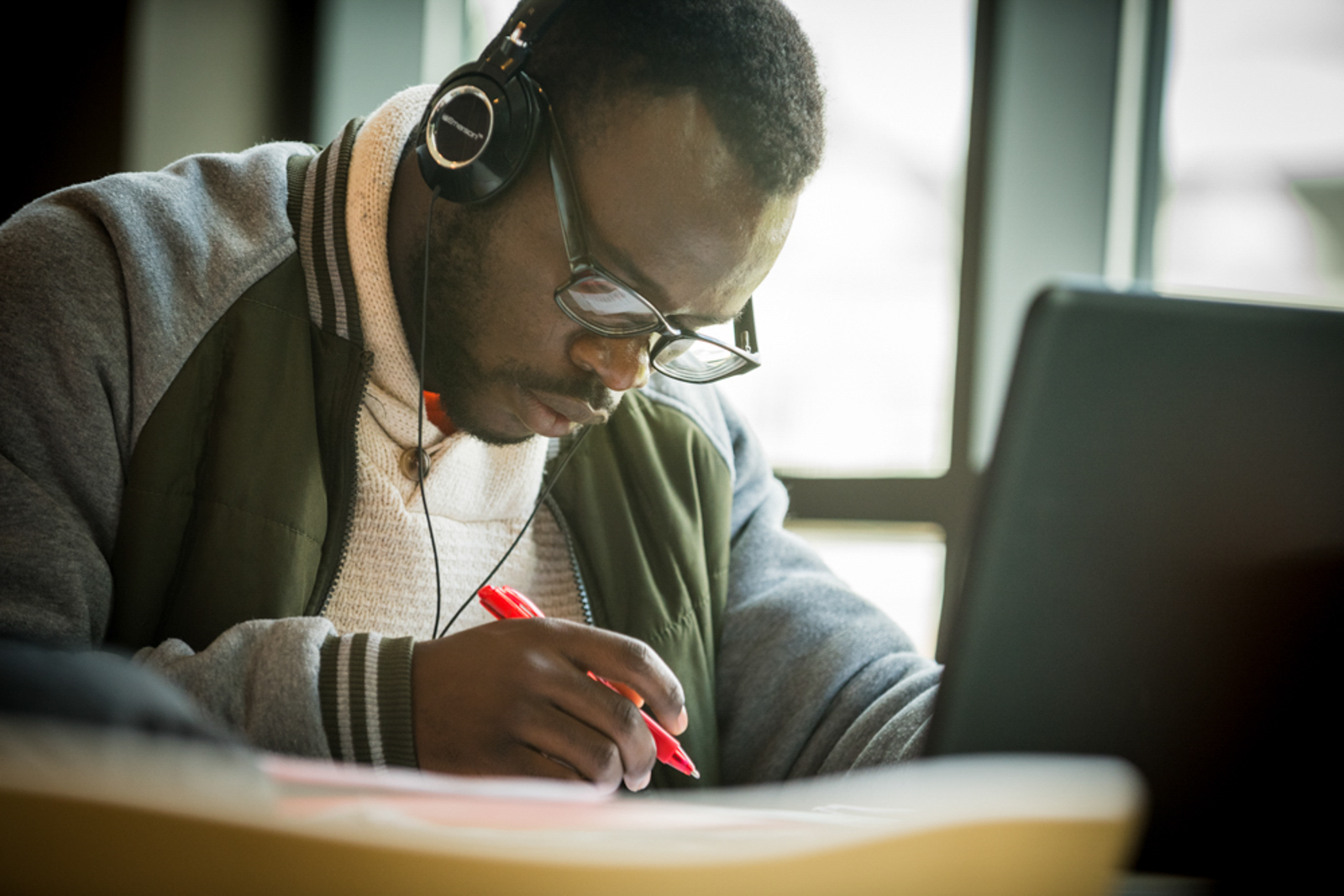 Student focusing on work, wearing headphones