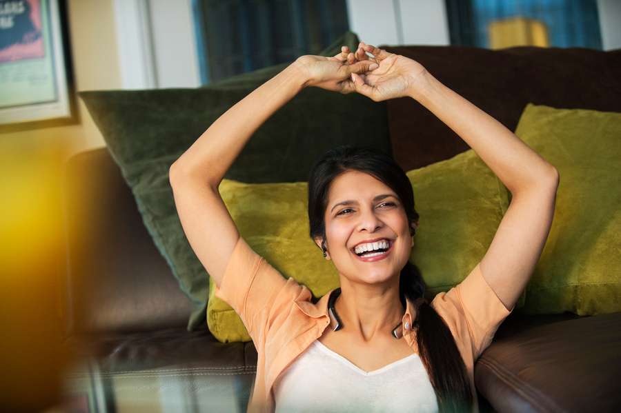 Woman smiling, leisurely stretching her arms up 