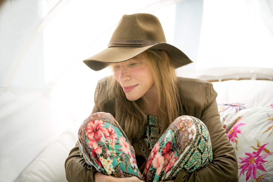 Singer-songwriter Carly Simon sits quietly in lounge chair, with a soft smile