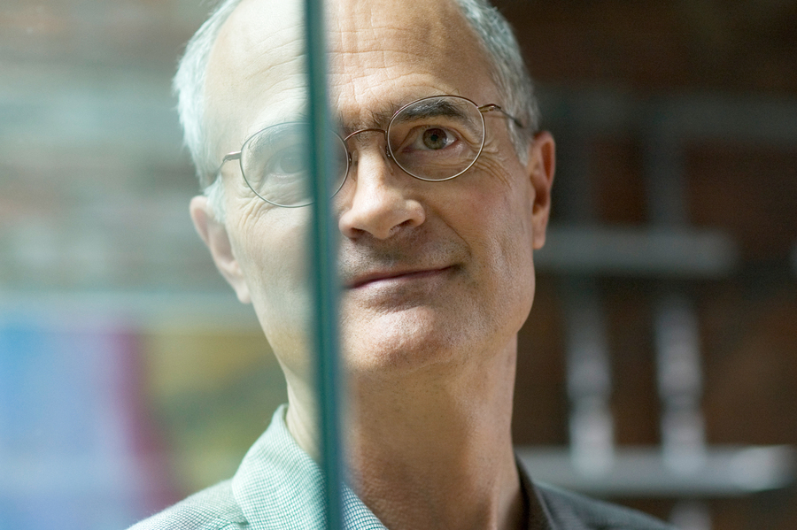 Close up of a man standing behind a glass that divides the image