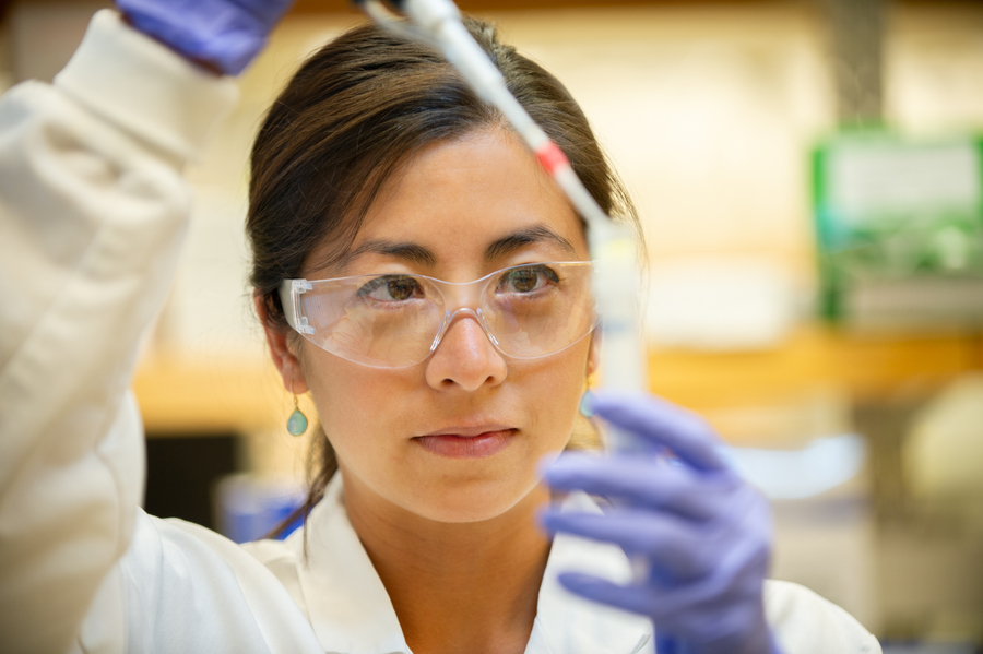 Female scientist working in a lab, with protective gear