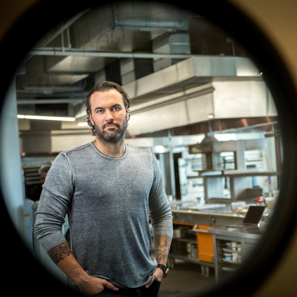 chef viewed through circular window in kitchen