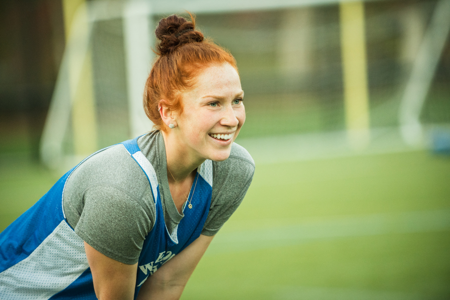 Young woman in a sports field, mid action