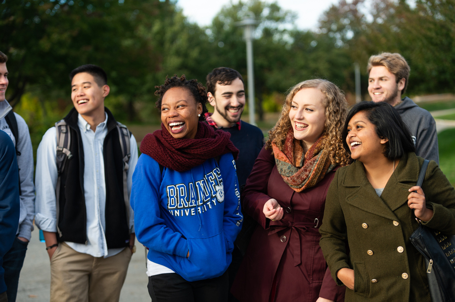 Group of students walking outdoors, with pleasant smiles